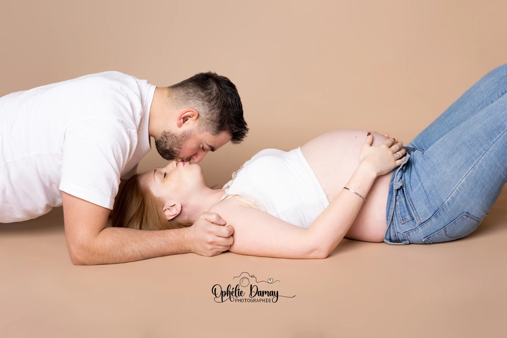 alt="couple attendant un bébé, s'embrassant tendrement"