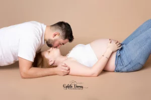 alt="couple attendant un bébé, s'embrassant tendrement"