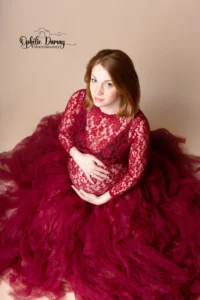 alt="Femme enceinte, enlaçant son ventre, dans une belle robe volumineuse"