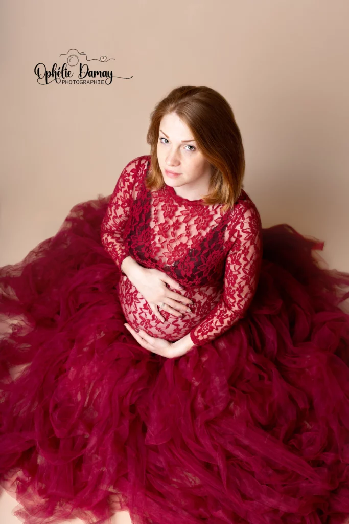 alt="Femme enceinte, enlaçant son ventre, dans une belle robe volumineuse"