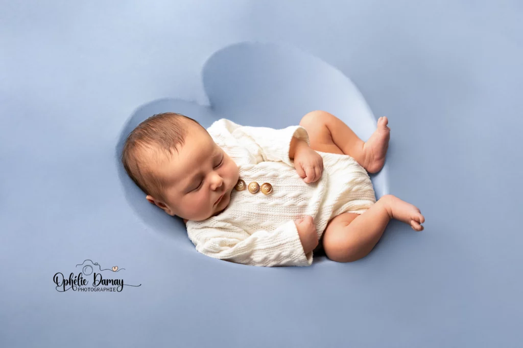 alt="Nouveau-né profondément endormi dans un contenant en forme de coeur"