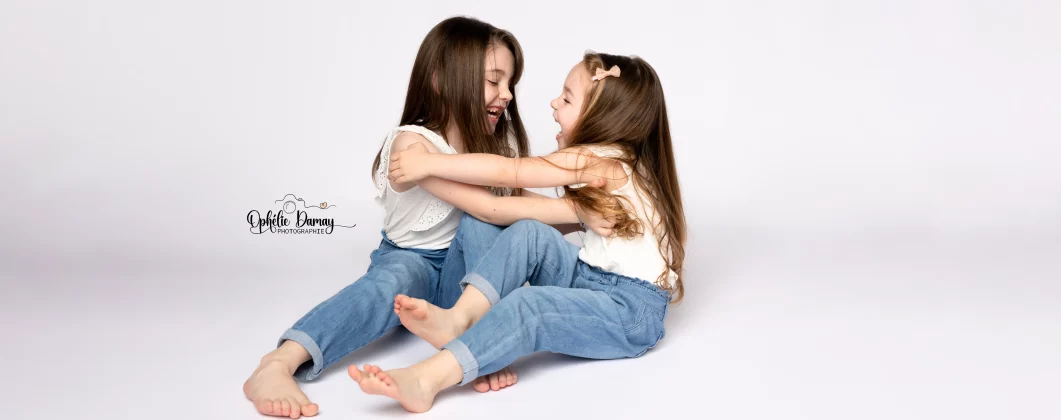 alt="enfants complices, riant en se faisant des chatouilles"