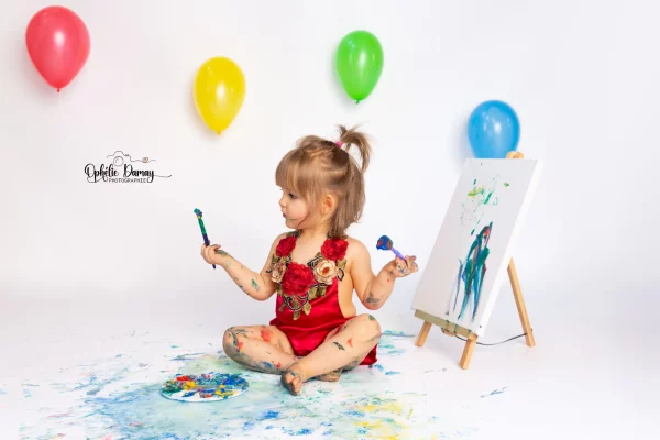 alt="Bébé jouant avec de la peinture"